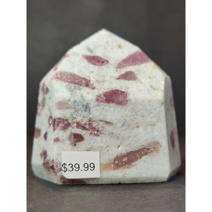 A quartz polished obelisk tower featuring a white base with embedded pinkish-red rubellite crystals
