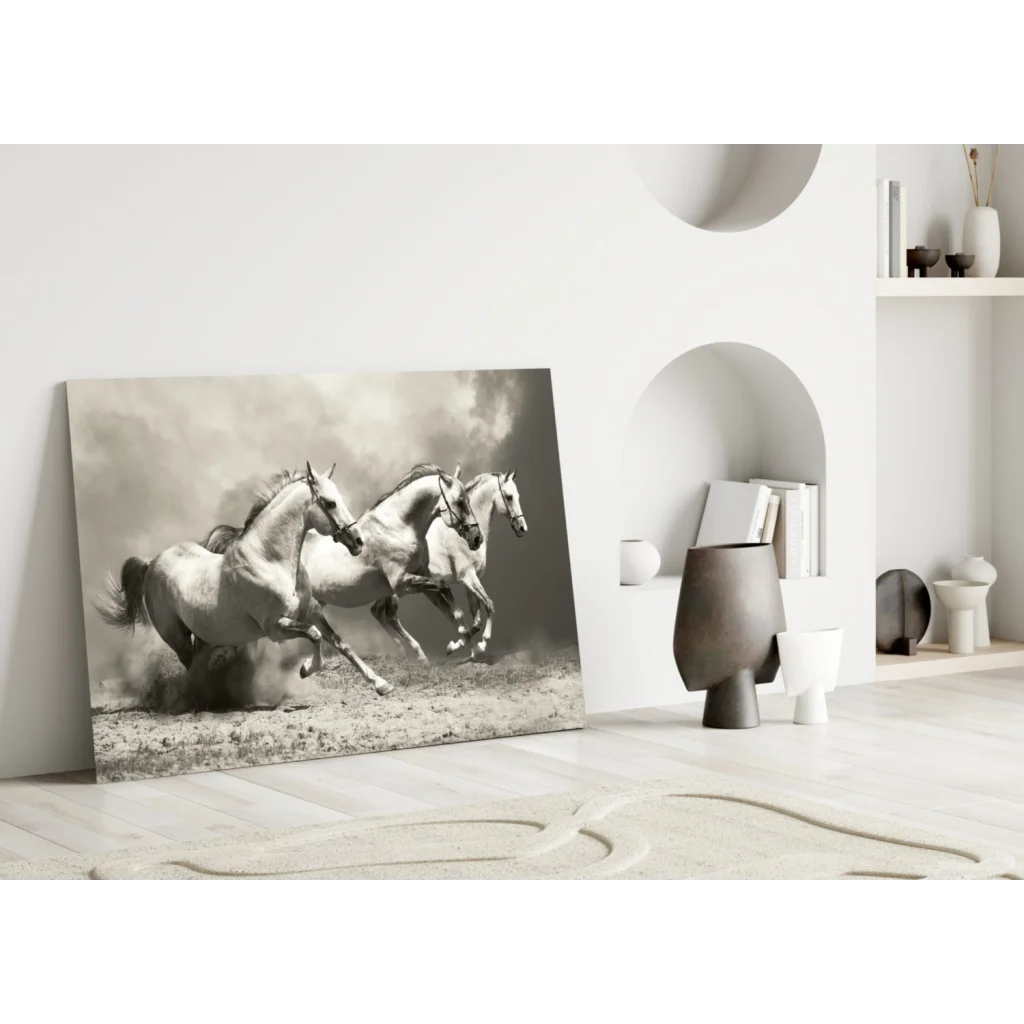Black-and-white canvas wall art of three white horses galloping in a dusty field