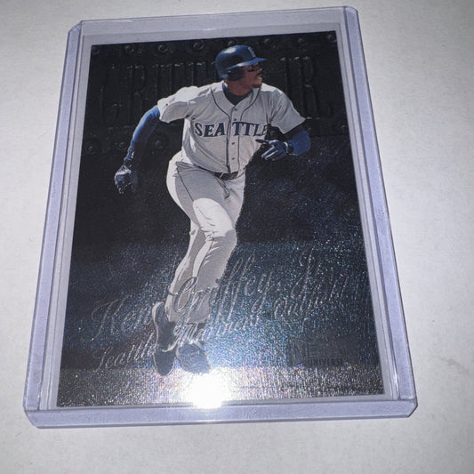 Graded baseball card in clear plastic case showing Ken Griffey Jr. in Seattle Mariners uniform running bases on metallic dark background.