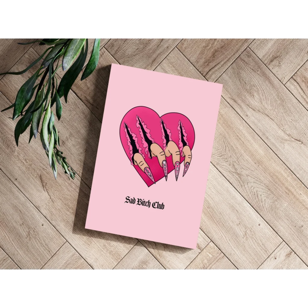 Pink heart-shaped notebook with claw nails and Sad Bitch Club text print