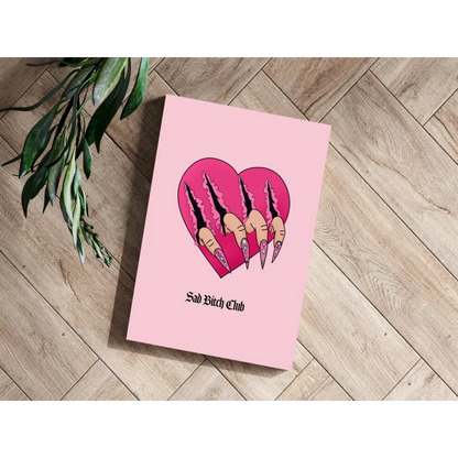 Pink heart-shaped notebook with claw nails and Sad Bitch Club text print