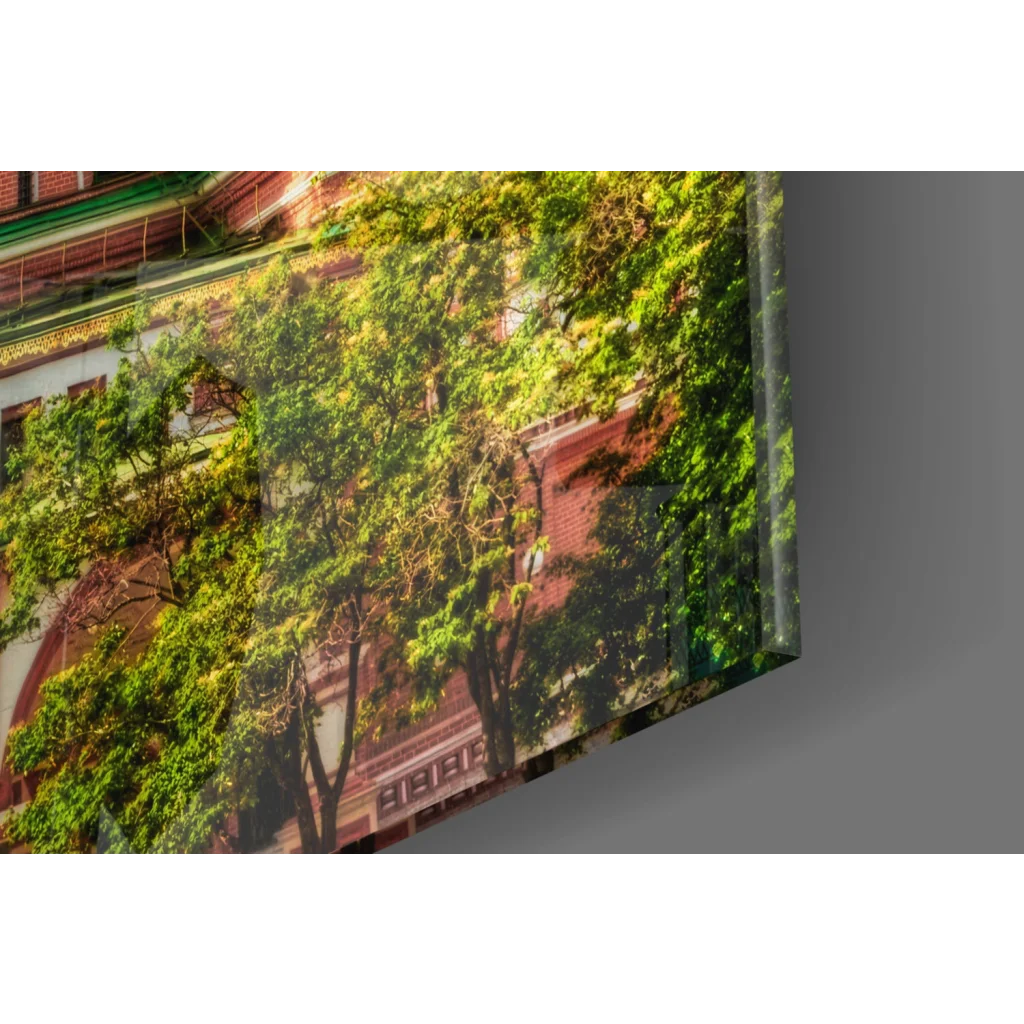 Vibrant green tree canopy over red brick architecture in stunning cathedral glass wall art