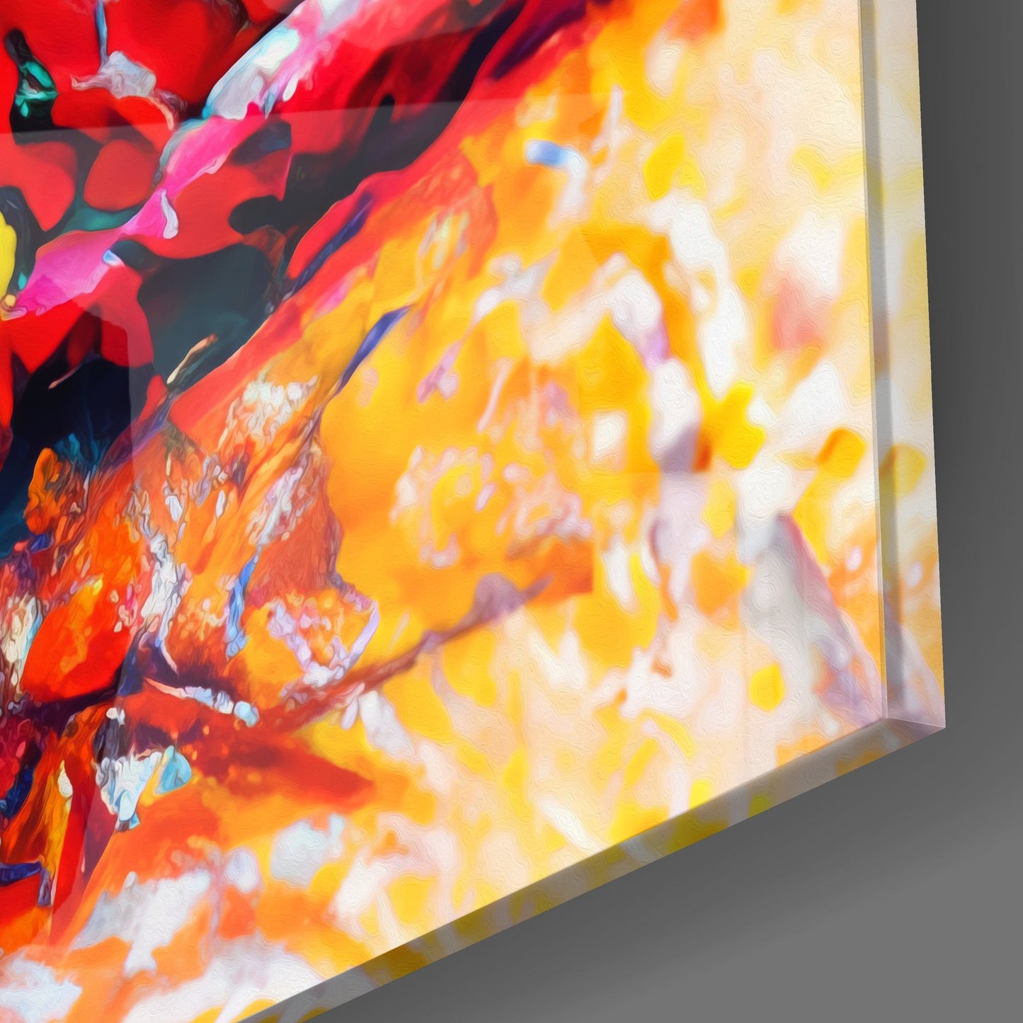 Close-up angled view of vibrant red, orange, and yellow abstract glass wall art with white accents and visible edge detail.
