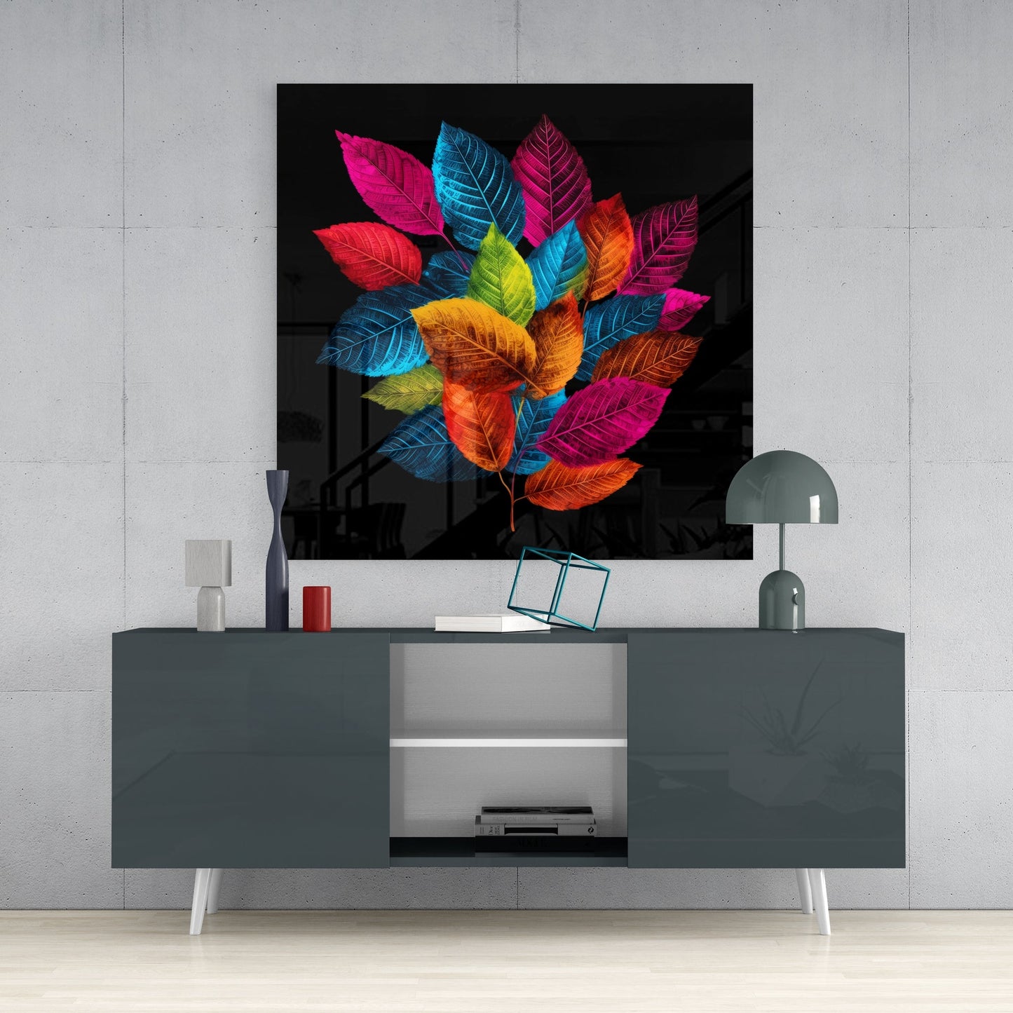 Colorful glass wall art depicting vibrant multicolored leaves on black background, displayed above gray media console in modern interior setting.