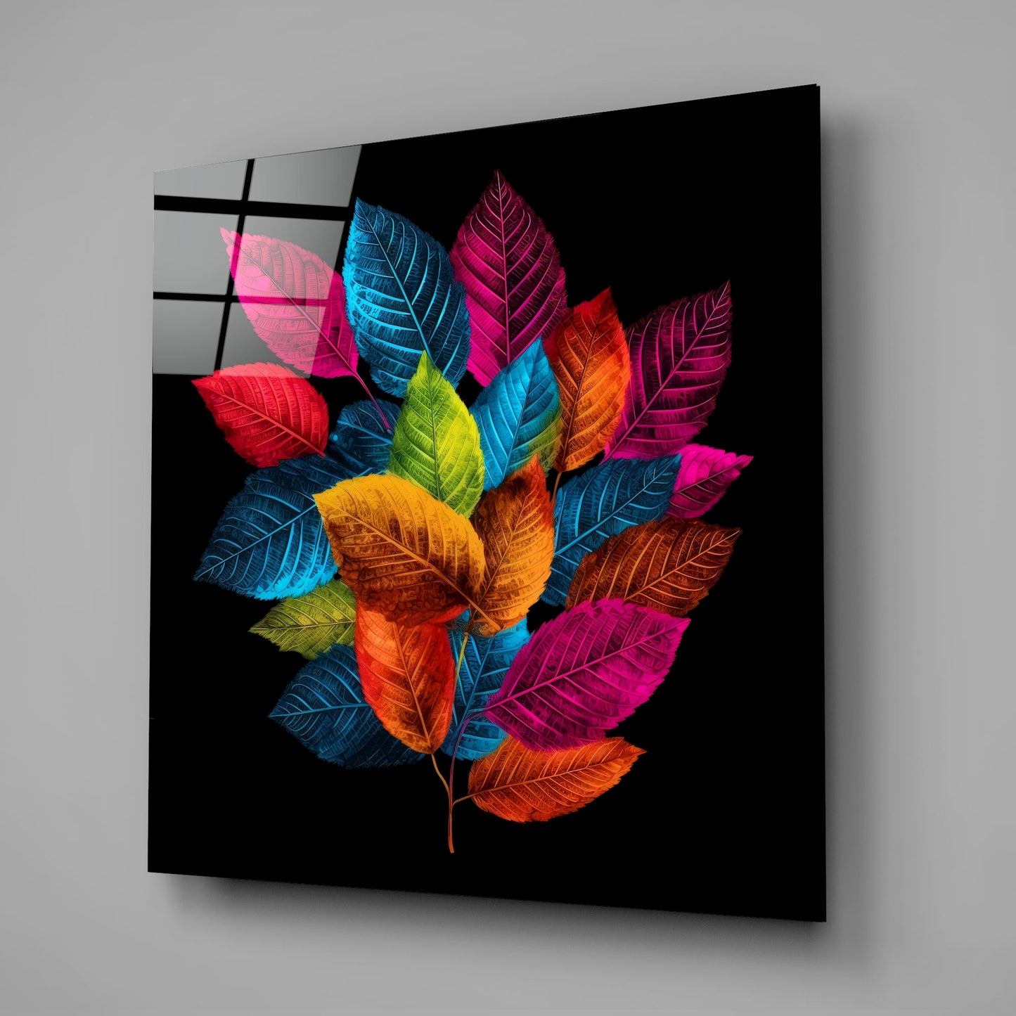 Angled perspective of black glass wall art displaying a vibrant bouquet of neon-colored leaves against dark background.