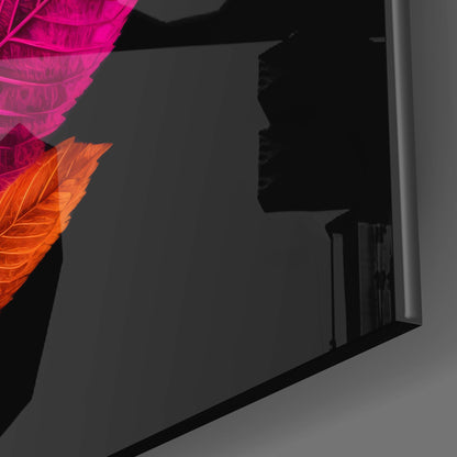 Close-up angled view of illuminated glass leaf wall art with magenta and orange neon-style lighting against dark background.