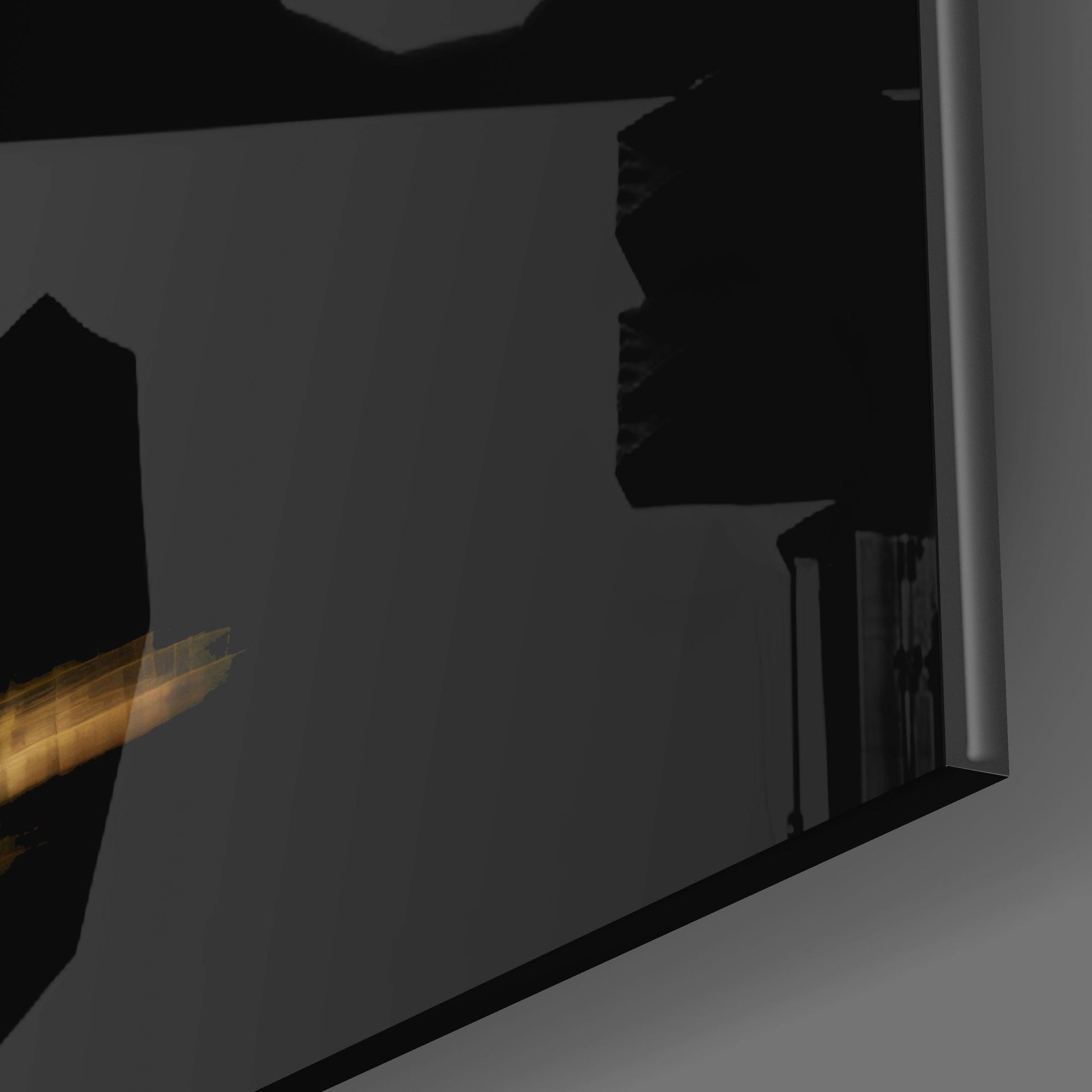 Close-up side view of black glass wall art panel with gold flame detail visible on left edge.
