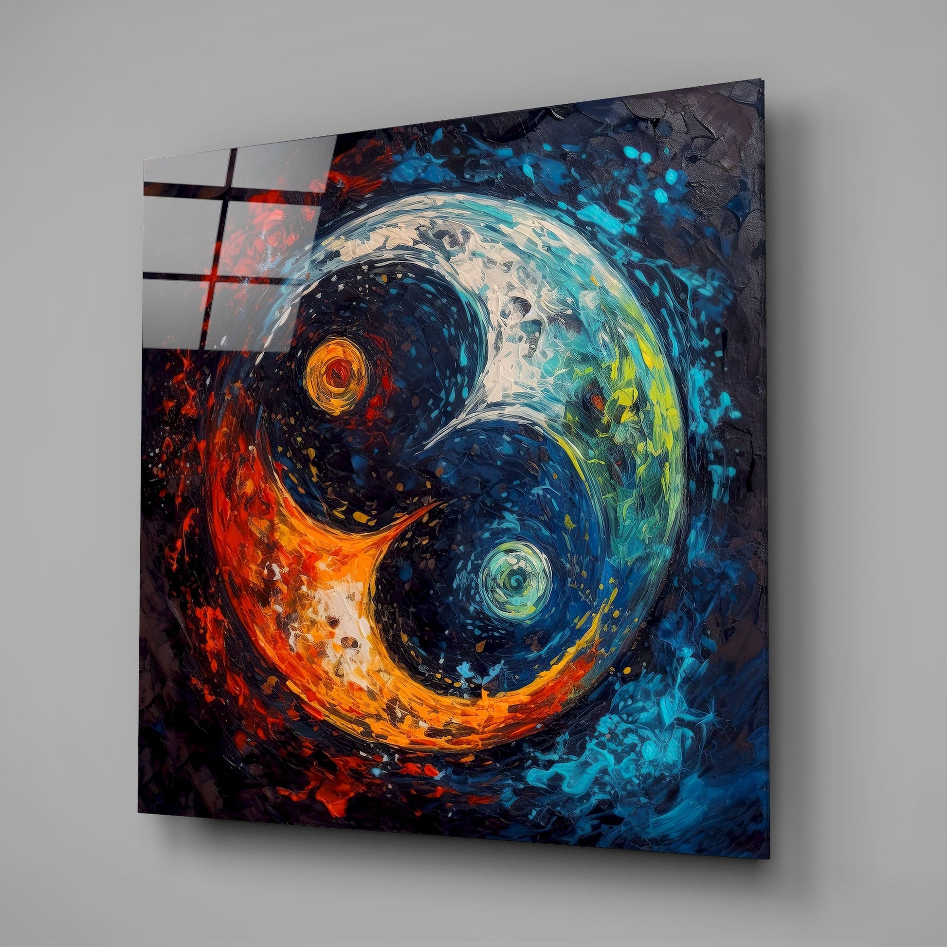 Angled view of glass wall art displaying a yin-yang symbol with fire-orange and cool blue-cyan swirling textures on gray background.