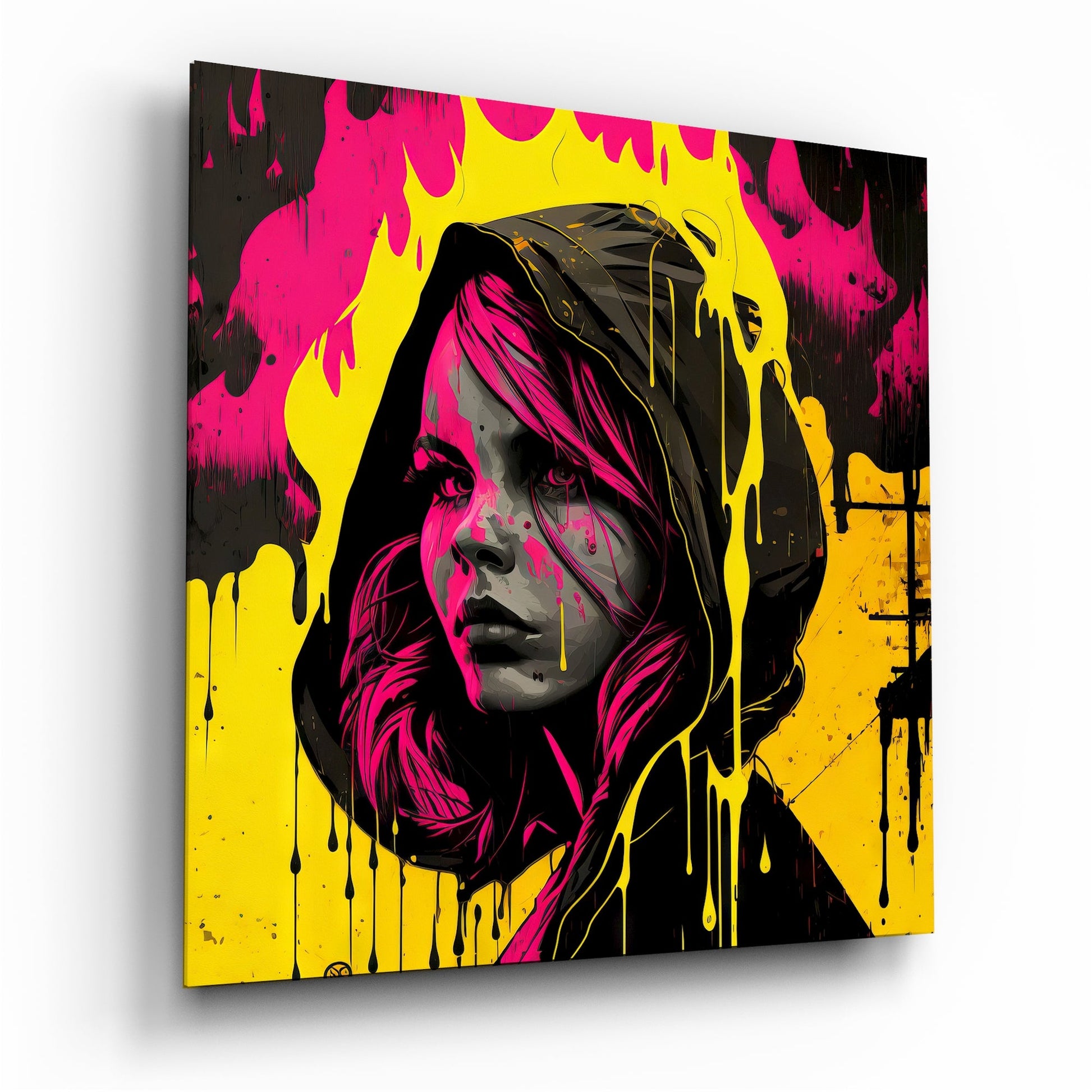 Angled view of glass wall art featuring a woman's portrait in magenta, yellow, and black with dripping paint effects and hood detail.