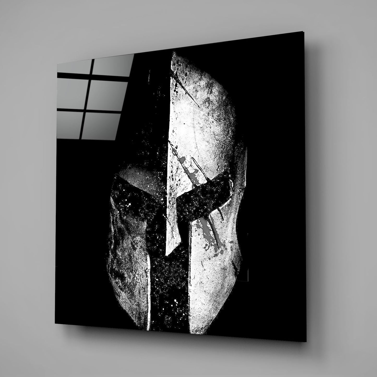 Black and white glass wall art displaying a split face design with geometric patterns and window grid detail in upper left corner.