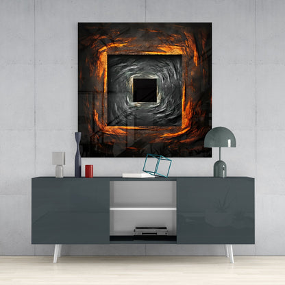 Square hole glass wall art with concentric orange and black swirling pattern displayed above gray media console in modern interior.