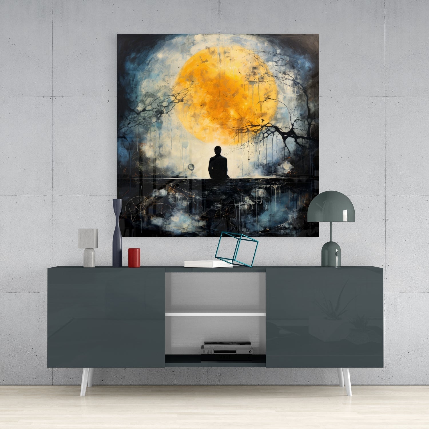 Glass wall art depicting a silhouetted figure beneath a golden moon with dark branches, displayed above a gray media console.