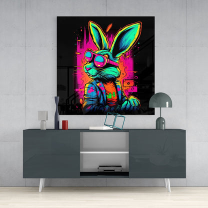 Vibrant neon retro rabbit wearing sunglasses and colorful jacket displayed as glass wall art above gray media console.