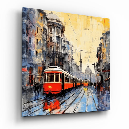 Red and white tram traveling down wet cobblestone street lined with weathered buildings under golden sky, displayed as angled glass wall art.