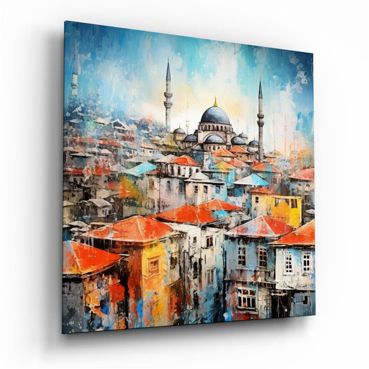 Angled perspective of glass wall art depicting a colorful cityscape with red-roofed buildings and a domed mosque with minarets against a blue sky.