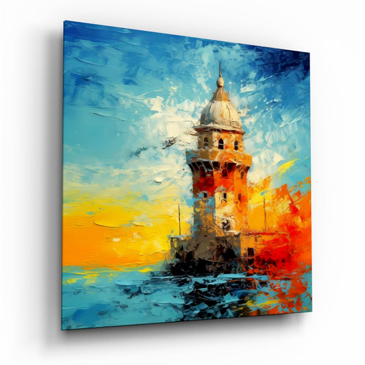 Angled view of a glass wall art panel depicting a red and white lighthouse tower against a vibrant blue sky and golden sunset, rendered in bold impasto brushstrokes.