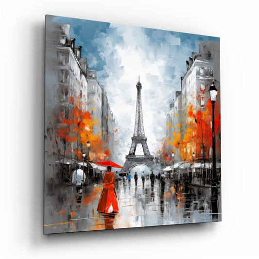 A glass canvas displaying a Parisian street scene with the Eiffel Tower centered, flanked by gray buildings with vibrant red and orange foliage, wet pavement, and a figure in red coat, mounted at an angle showing shadow and depth.