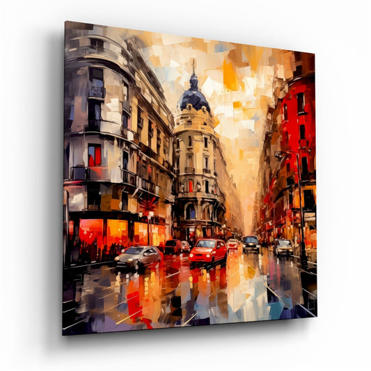 Modern art glass print showing a wet European street with period architecture, red cars, and warm amber-toned buildings under a golden sky.