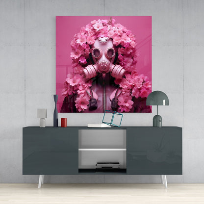 Pink glass wall art depicting a gas mask surrounded by pink flowers displayed above a dark gray media console in a modern interior setting.