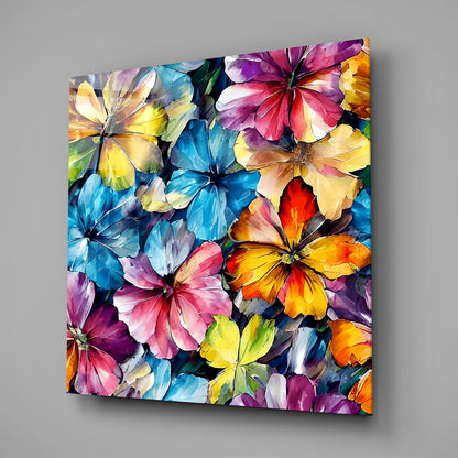 Colorful glass wall art panel displaying overlapping painted flowers in blue, pink, yellow, orange, and purple tones against dark background.