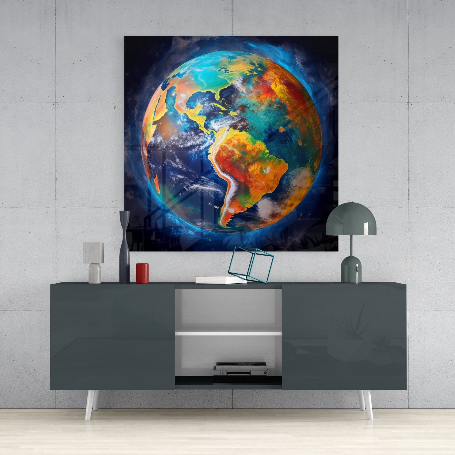 Colorful glass wall art depicting Earth with blue oceans, orange continents, and yellow outlines mounted above a gray console table with decor.