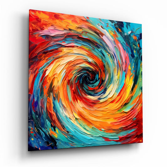 Angled perspective view of vibrant impasto glass wall art featuring a swirling vortex of orange, red, yellow, teal, and blue brushstrokes converging toward a dark center.