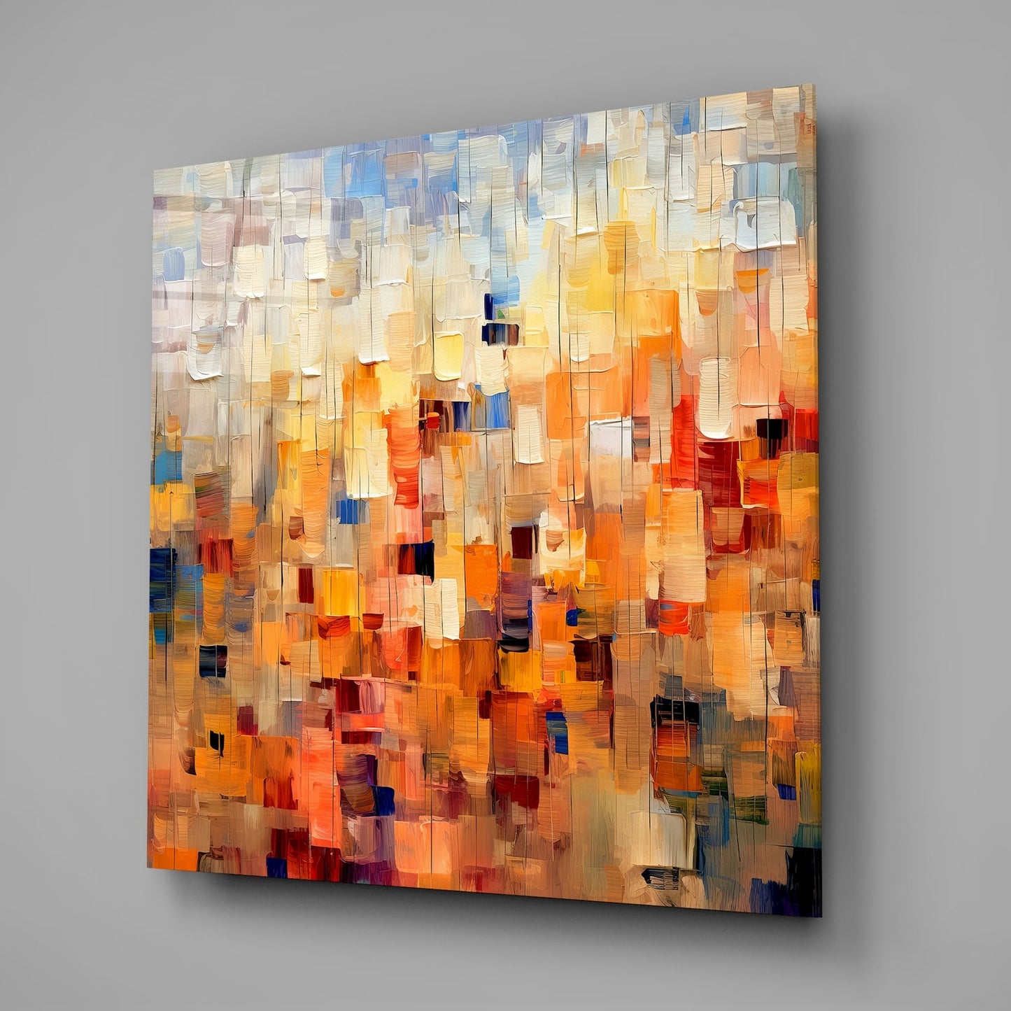 Abstract geometric glass wall art with layered translucent rectangles in warm oranges, yellows, blues, and creams, displayed at an angle against gray wall.