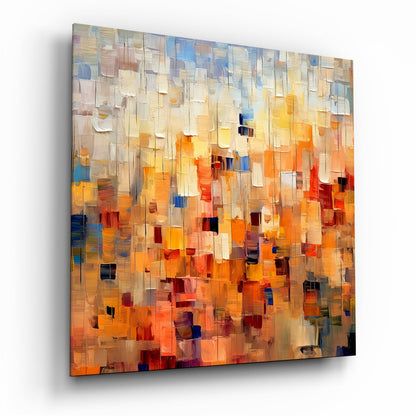 Abstract glass wall art panel displaying layered translucent rectangular tiles in warm oranges, yellows, creams, and cool blue accents, photographed at an angle showing depth and dimension.