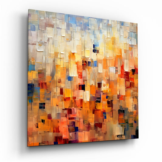 Abstract glass wall art panel displaying layered translucent rectangular tiles in warm oranges, yellows, creams, and cool blue accents, photographed at an angle showing depth and dimension.