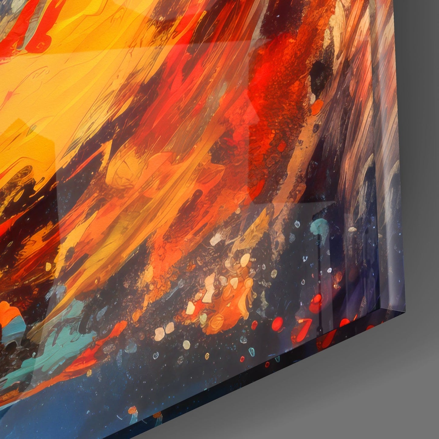 Close-up angled view of glass wall art displaying vibrant yellow, orange, and red streaks blending into deep blue with scattered colorful speckles.