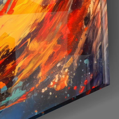 Close-up angled view of glass wall art displaying vibrant yellow, orange, and red streaks blending into deep blue with scattered colorful speckles.