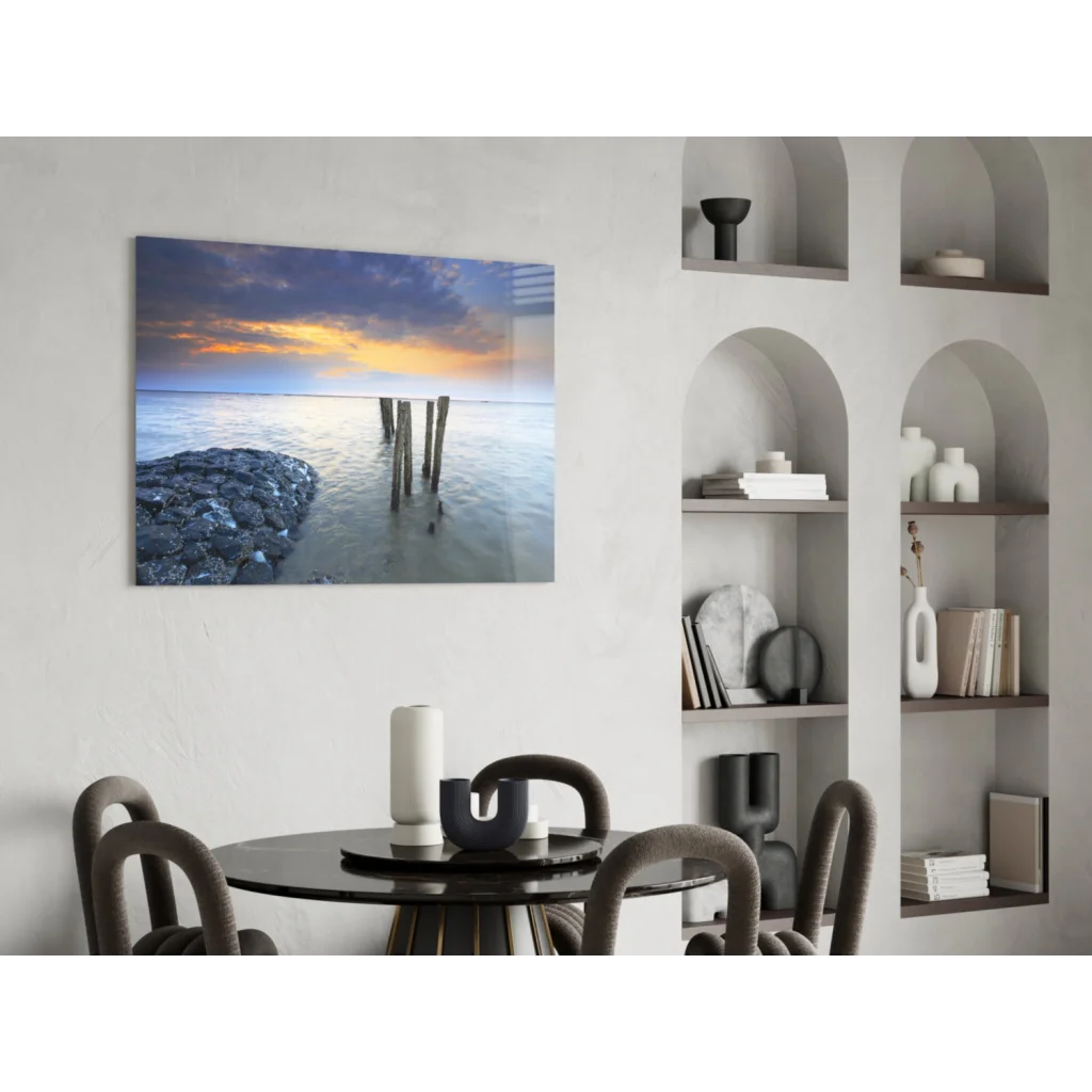 Serene sunset glass wall art with wooden pilings and rocks
