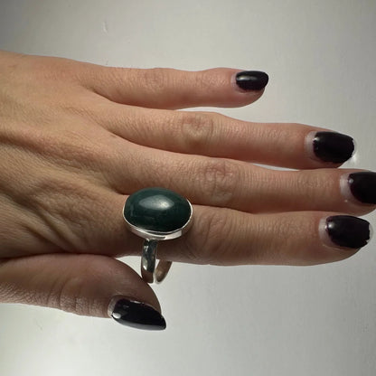 Sleek silver serpentine ring with smooth oval deep green gemstone
