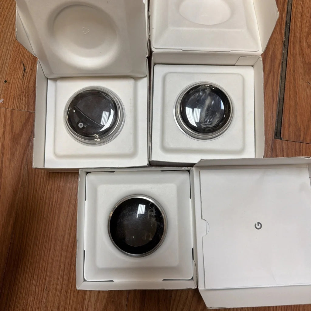 Three Google Nest Hub devices in white boxes with black circular screens