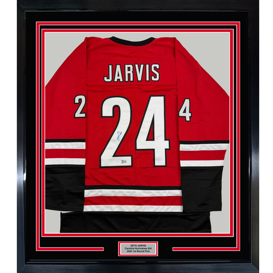 Red Carolina Hurricanes hockey jersey number 24 signed by Seth Jarvis, displayed in black frame with authentication plaque.