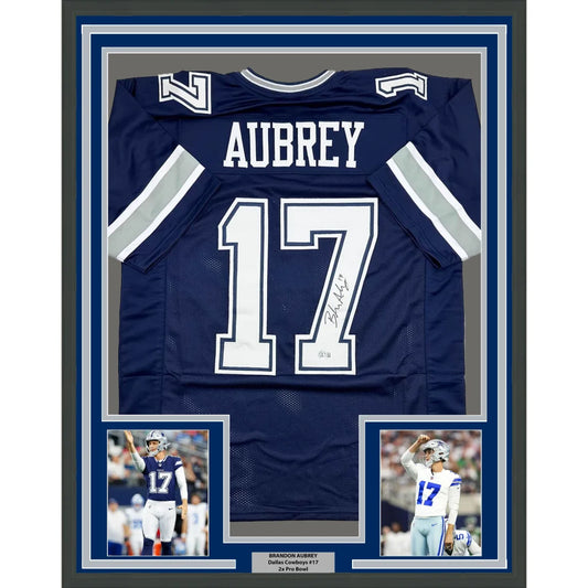 Signed navy blue football jersey in white lettering, framed
