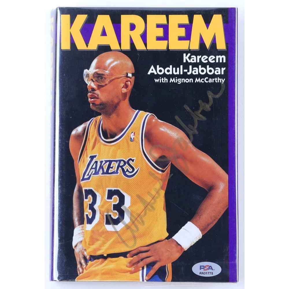 Signed Kareem Abdul-Jabbar Lakers jersey cover on Kareem hardcover book with PSA DNA