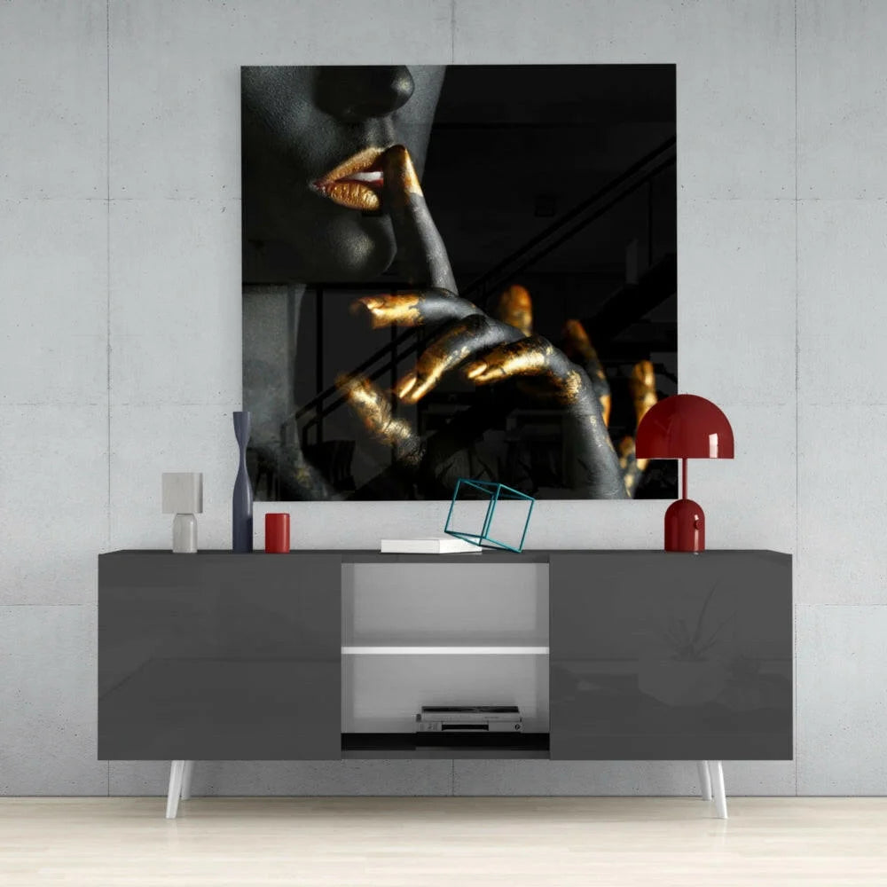 Black and gold abstract glass wall art of woman’s lips and hand