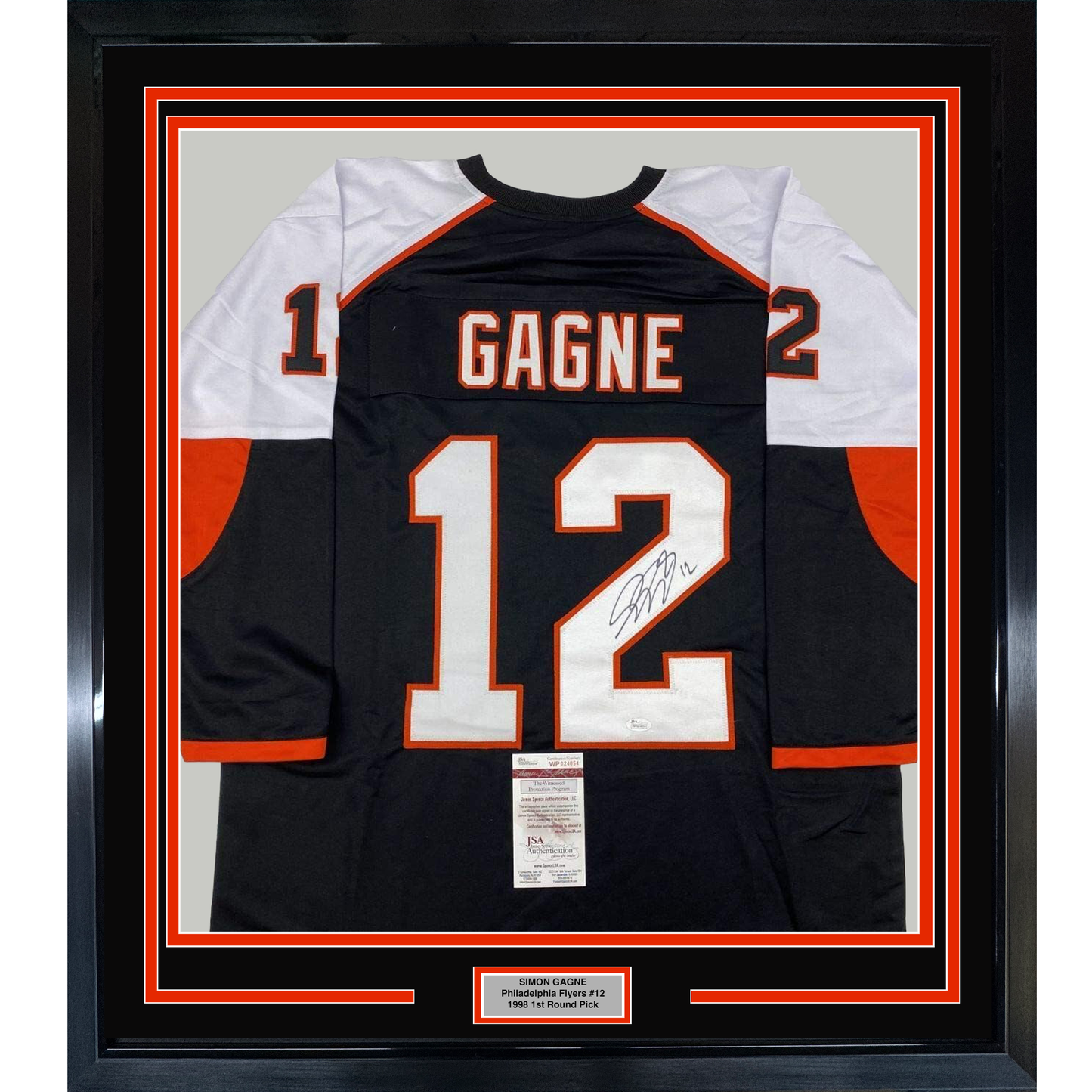 Framed black Philadelphia Flyers jersey #12 with "GAGNE" nameplate and signature, displayed front-facing with white and orange trim and JSA authentication certificate.