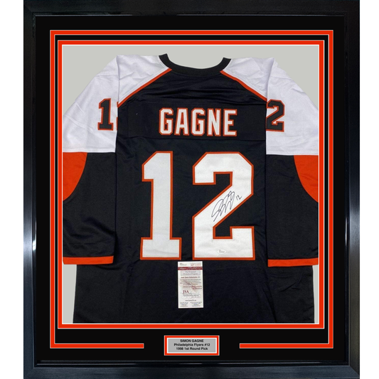 Framed black Philadelphia Flyers jersey #12 with "GAGNE" nameplate and signature, displayed front-facing with white and orange trim and JSA authentication certificate.