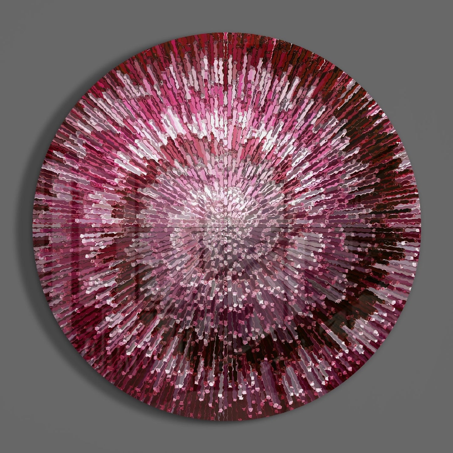 Circular glass wall art with radiating pink, red, and white glass pieces emanating from a bright center against gray background.