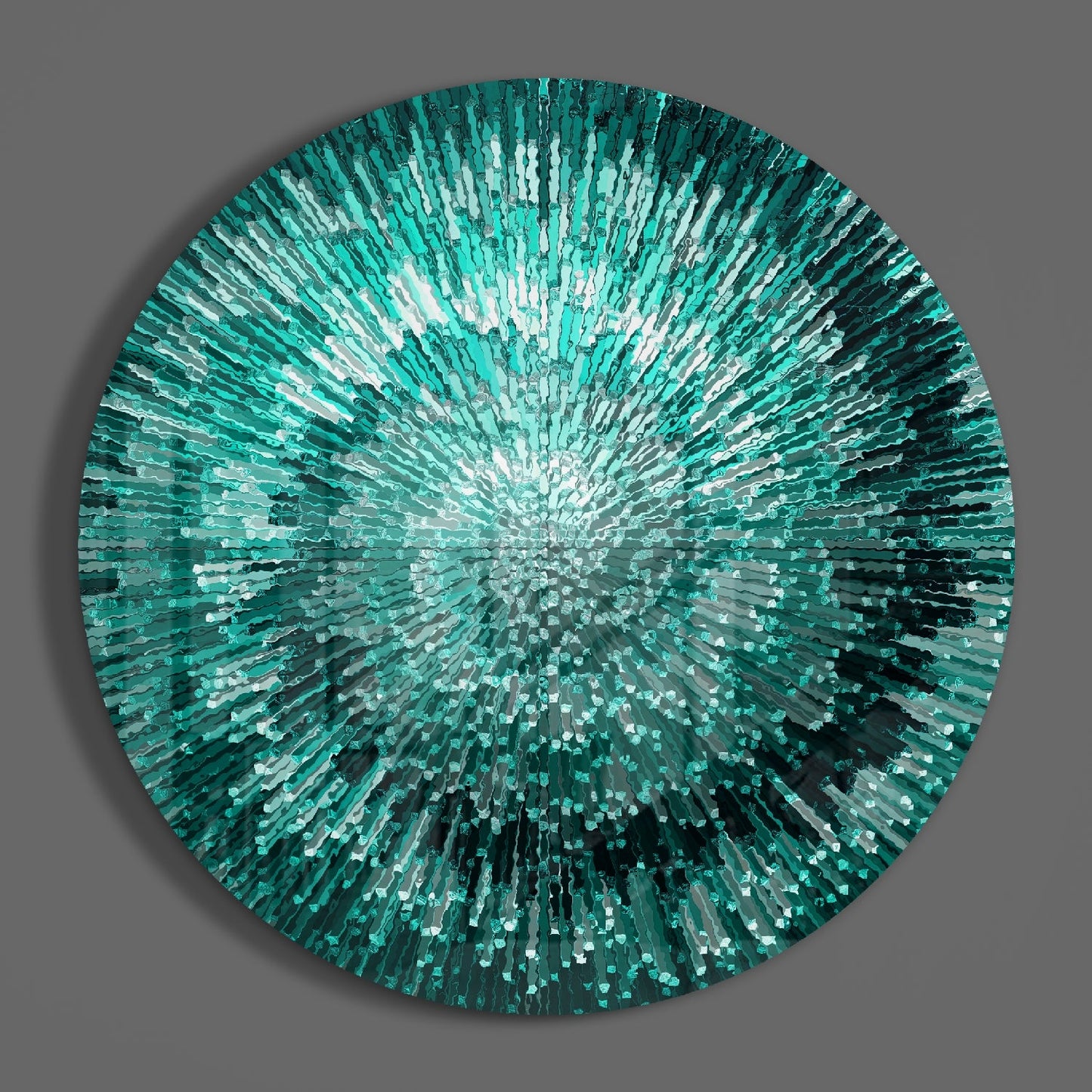 Circular glass wall art with radiating teal and white glass shards creating a starburst pattern against a gray background.