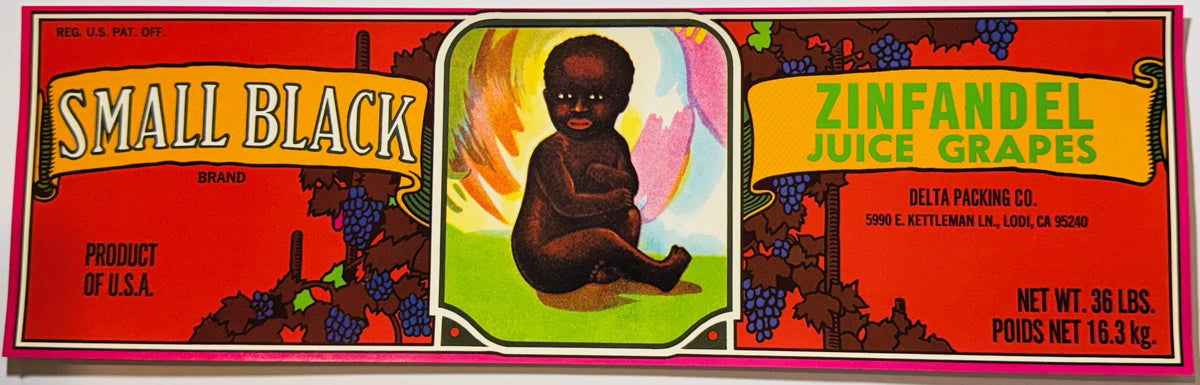 Vintage 1970s Small Black Brand Zinfandel Juice Grapes crate label from Delta Packing Co., Lodi, California: a long red lug label with yellow scroll banners, grapevines and a painted baby seated on green grass in the centre panel, pink border