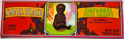 Vintage 1970s Small Black Brand Zinfandel Juice Grapes crate label from Delta Packing Co., Lodi, California: a long red lug label with yellow scroll banners, grapevines and a painted baby seated on green grass in the centre panel, pink border
