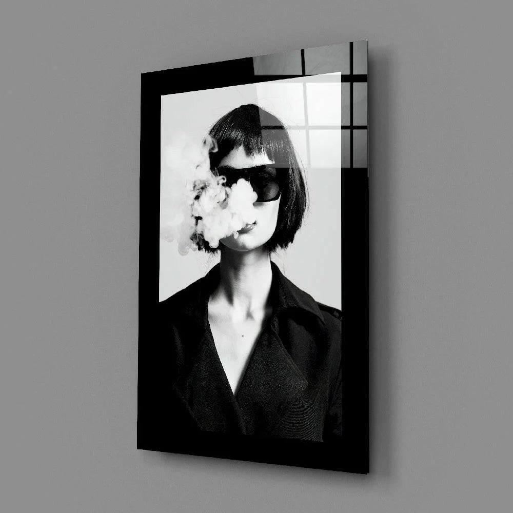 Black framed glass wall art print of woman exhaling smoke in sunglasses