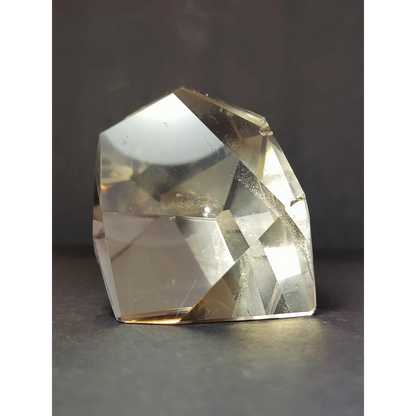 A smoky clear quartz polished free form sculpture with translucent faceted citrine crystal and warm golden hue