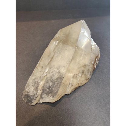 A smoky quartz natural elestial point featuring translucent pale quartz with natural facets and earthy mineral inclusions