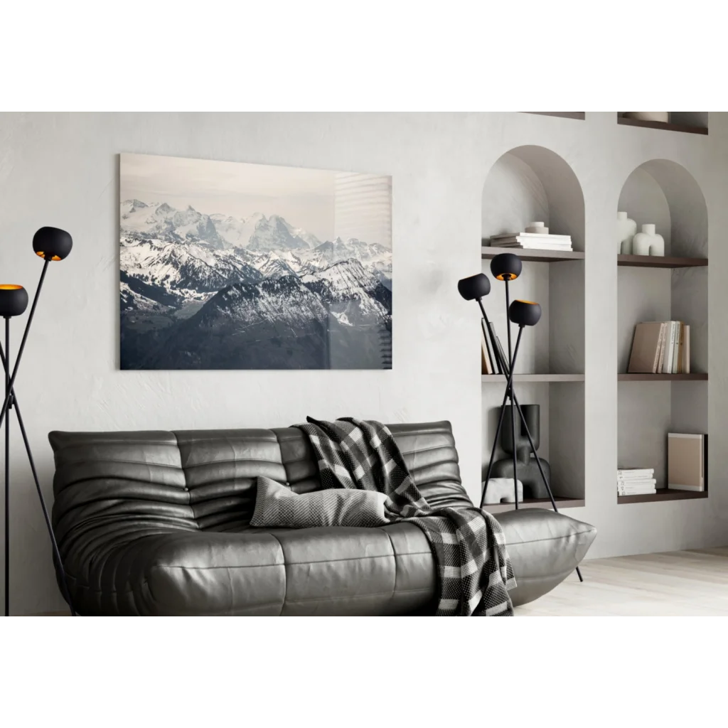 Black leather sofa with quilted texture and plaid throw near glass wall art