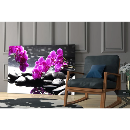Vibrant purple orchids on black stones in glass wall art print