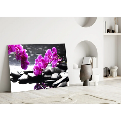 Vibrant purple orchids on black stones in glass wall art print